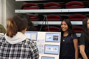 female presenting her poster to another individual