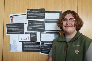 student smiling in front of poster