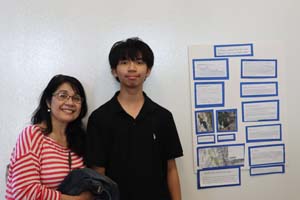 male and female standing next to poster